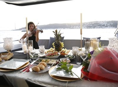 Romantic dinner setup on a private yacht with live violin music on the Bosphorus in Istanbul.